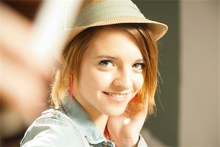 Head and shoulders portrait of teenage girl wearing hat in studio. Stock Photo - Premium Royalty-Free, Code: 600-06553553