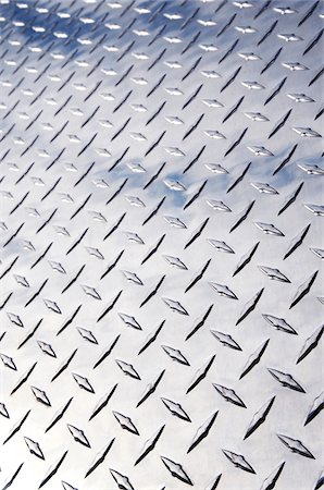 silver textures - Low angle view of stainless steel diamond plate facade with reflection of clouds Photographie de stock - Premium Libres de Droits, Code: 600-06570964