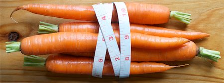 diet calories - view of fresh carrots on cedar board with measuring tape wrap Stock Photo - Premium Royalty-Free, Code: 600-06570962