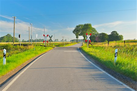 europe road - Railroad Crossing in the Summer, Toenning, Schleswig-Holstein, Germany Stock Photo - Premium Royalty-Free, Code: 600-06571059