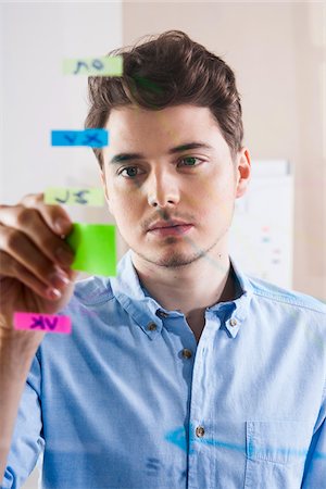 self adhesive note - Young Man Working in an Office, Looking Through Glass Board, Germany Stock Photo - Premium Royalty-Free, Code: 600-06620944
