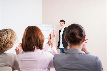 simsearch:600-06645495,k - People Clapping for Man giving Business Presentation Fotografie stock - Premium Royalty-Free, Codice: 600-06645494