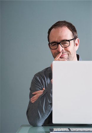 fun reading - Businessman Using Computer in Studio Stock Photo - Premium Royalty-Free, Code: 600-06645879