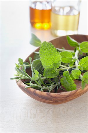 simsearch:600-06899791,k - Fresh herbs in a bowl and bottles of oil for aromatherapy Photographie de stock - Premium Libres de Droits, Code: 600-06674997