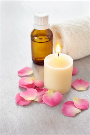 simsearch:600-06674986,k - Rose petals, candle, rolled towel and a bottle of essential oil for aromatherapy Fotografie stock - Premium Royalty-Free, Codice: 600-06674990