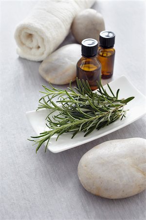Sprig of rosemary, fresh herbs, a towel and bottles of essential oil for aromatherapy Stockbilder - Premium RF Lizenzfrei, Bildnummer: 600-06674991
