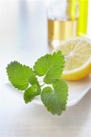 simsearch:600-06675025,k - Fresh lemon balm with a lemon and bottles of aromatic oil for aromatherapy Foto de stock - Royalty Free Premium, Número: 600-06675008