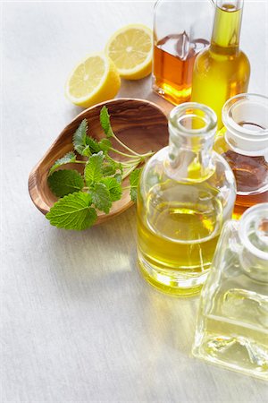 Sprig of lemon balm in a bowl, herbs, lemon and bottles of essential oil Stock Photo - Premium Royalty-Free, Code: 600-06675018