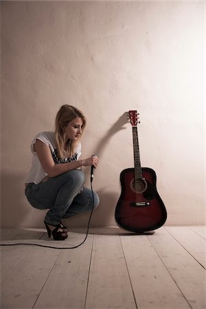 Woman Crouching with Microphone beside Guitar Photographie de stock - Premium Libres de Droits, Code: 600-06675149