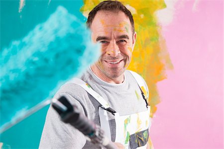 paintings in home - Portrait of Mature Man with Paint Roller Renovating his Home Stock Photo - Premium Royalty-Free, Code: 600-06679394