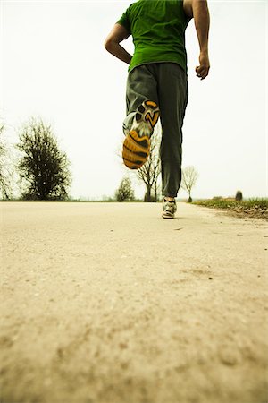 exercise men backside - Low Angle View of Mature Man Running, Lampertheim, Hesse, Germany Foto de stock - Sin royalties Premium, Código: 600-06679399