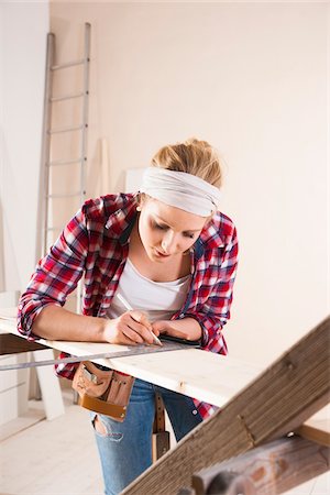 Studio Shot of Young Woman Measuring Lumber Stock Photo - Premium Royalty-Free, Code: 600-06671756