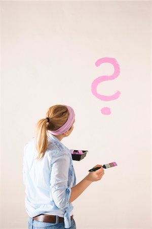 simsearch:600-06685192,k - Studio Shot of Young Woman Painting a Question Mark on a Wall Photographie de stock - Premium Libres de Droits, Code: 600-06671775