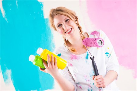 simsearch:600-06671757,k - Studio Shot of Young Woman Holding Paint Roller, Deciding Between Paint Colours Stock Photo - Premium Royalty-Free, Code: 600-06671792