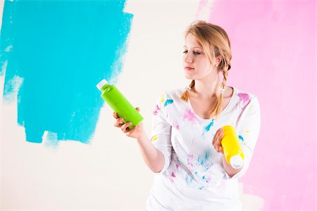 Studio Shot of Young Woman Holding Paint Containers, Deciding Between Paint Colours Photographie de stock - Premium Libres de Droits, Code: 600-06671793