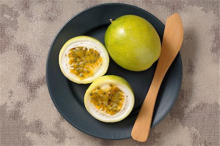 Overhead View of Passionfruits on Plate, One Cut in Half Stock Photo - Premium Royalty-Free, Code: 600-06671817