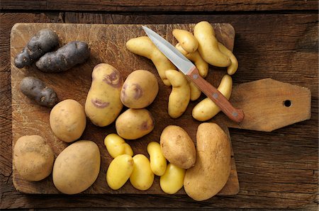 staple food - Overhead View of Varieties of Potatoes on Cutting Board with Knife Photographie de stock - Premium Libres de Droits, Code: 600-06671827