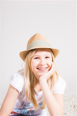 straw hat - Portrait of Girl with Braces wearing Hat in Studio Stock Photo - Premium Royalty-Free, Code: 600-06685177