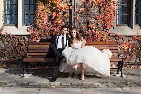 Portrait of Bride and Groom Sitting on Bench in Autumn, Toronto, Ontario, Canada Stock Photo - Premium Royalty-Free, Code: 600-06701871