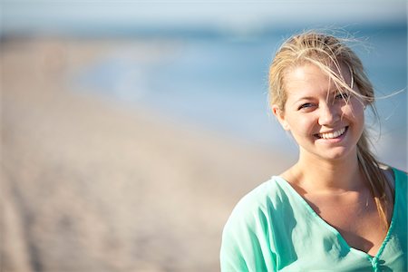 simsearch:600-06531455,k - Close-up Portrait of Young Woman on Beach, Looking at Camera and Smiling, Palm Beach Gardens, Palm Beach County, Florida, USA Stock Photo - Premium Royalty-Free, Code: 600-06701901