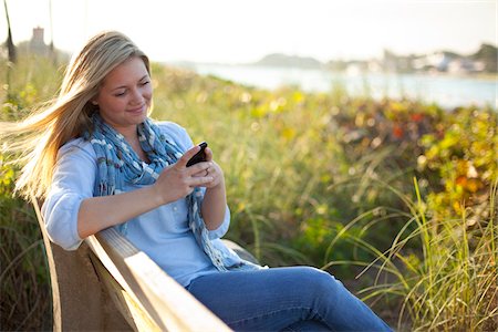 radius201311 - Young Woman Sitting on Bench at Beach, Texting on Cell Phone, Jupiter, Palm Beach County, Florida, USA Foto de stock - Sin royalties Premium, Código: 600-06701918