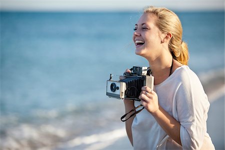 Young Woman Taking Pictures at Beach with Camera, Palm Beach Gardens, Palm Beach, Florida, USA Photographie de stock - Premium Libres de Droits, Code: 600-06701911