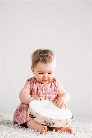 playing music alone - Portrait of Baby Girl holding Tambourine, Studio Shot Stock Photo - Premium Royalty-Free, Code: 600-06752372