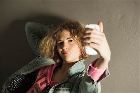 Teenage Girl taking Self Portrait with Camera Phone, Studio Shot Foto de stock - Sin royalties Premium, Código: 600-06752484