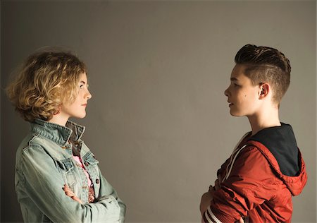 regard furieux - Teenage Boy and Girl Staring at Each Other with Arms Crossed, Studio Shot Photographie de stock - Premium Libres de Droits, Code: 600-06752488