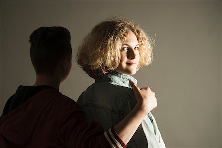 Teenage Boy with Arm around Shoulder of Teenage Girl who is Looking Back, Studio Shot Photographie de stock - Premium Libres de Droits, Code: 600-06752495