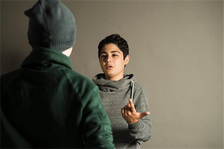 effrayé - Teenage Boy Talking to another Boy, Studio Shot Photographie de stock - Premium Libres de Droits, Code: 600-06752501