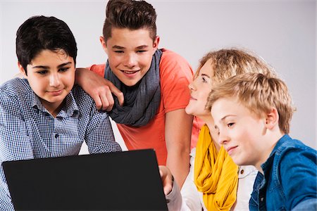 Teenagers Looking at Laptop Computer, Studio Shot Stock Photo - Premium Royalty-Free, Code: 600-06752517