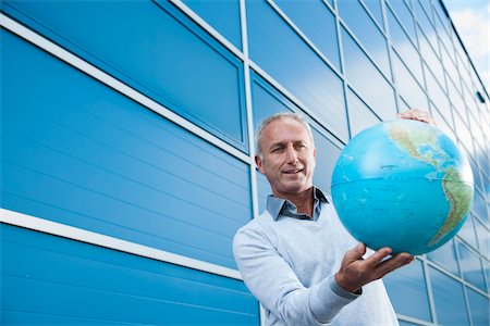 portrait dans l'exercice d'un métier - Businessman Holding Globe Outdoors, Mannheim, Baden-Wurttemberg, Germany Photographie de stock - Premium Libres de Droits, Code: 600-06773367