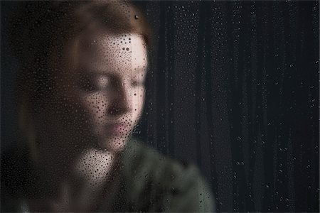 Portrait of teenage girl behind window, wet with raindrops Stock Photo - Premium Royalty-Free, Code: 600-06786755