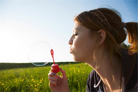 Close-up of teenage girl blowing bubbles in field, Germany Photographie de stock - Premium Libres de Droits, Code: 600-06786808