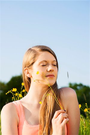 simsearch:700-06826408,k - Portrait of young woman sitting in field enjoying nature, Germany Stock Photo - Premium Royalty-Free, Code: 600-06786815