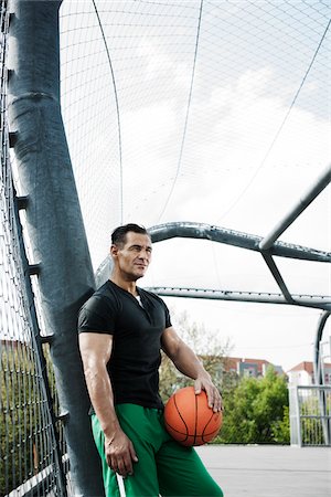 simsearch:600-06786850,k - Portrait of mature man standing on outdoor outdoor basketball court, Germany Stock Photo - Premium Royalty-Free, Code: 600-06786827