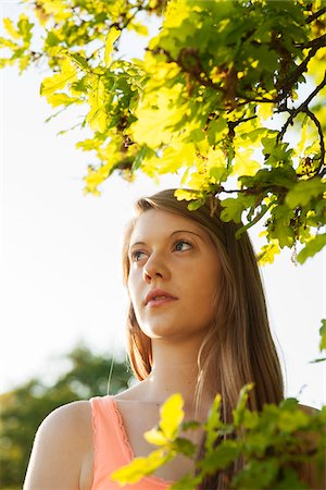 simsearch:600-07156261,k - Close-up portrait of young woman standing under tree branch, Germany Foto de stock - Sin royalties Premium, Código: 600-06786821