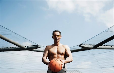 simsearch:600-06841749,k - Portrait of mature man on outdoor basketball court, getting ready to throw basketball, Germany Photographie de stock - Premium Libres de Droits, Code: 600-06786840