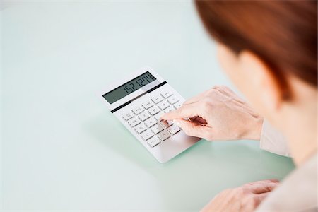 simsearch:600-03537954,k - Over the Shoulder View of Mature Woman using Calculator in Office Stock Photo - Premium Royalty-Free, Code: 600-06787019