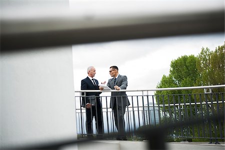 Mature businessmen standing on bridge talking, Mannheim, Germany Stock Photo - Premium Royalty-Free, Code: 600-06782215