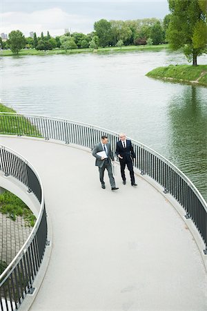 simsearch:600-06782244,k - Mature businessmen on walkway talking, Mannheim, Germany Photographie de stock - Premium Libres de Droits, Code: 600-06782210