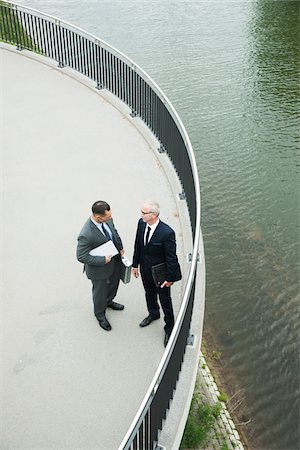 simsearch:600-06773372,k - Mature businessmen standing on walkway talking, Mannheim, Germany Stock Photo - Premium Royalty-Free, Code: 600-06782212