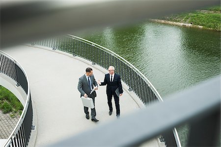 simsearch:600-06782244,k - Mature businessmen on walkway talking, Mannheim, Germany Photographie de stock - Premium Libres de Droits, Code: 600-06782213