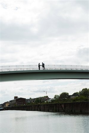 railing - Silhouette of mature businessmen standing on bridge shaking hands, Mannheim, Germany Stock Photo - Premium Royalty-Free, Code: 600-06782229