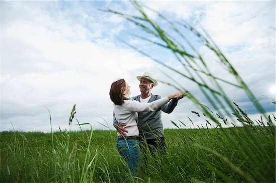 Mature couple dancing in field of grass, Germany Stock Photo - Premium Royalty-Free, Artist: Uwe Umstätter, Image code: 600-06782244