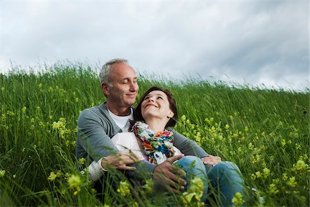 simsearch:600-06782244,k - Mature couple sitting in field of grass, embracing, Germany Photographie de stock - Premium Libres de Droits, Code: 600-06782254