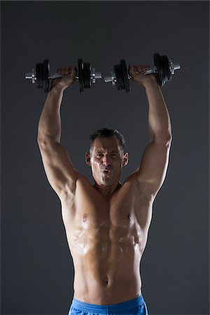 sport man body - Muscular Man Lifting Weights, Studio Shot Stock Photo - Premium Royalty-Free, Code: 600-06841757