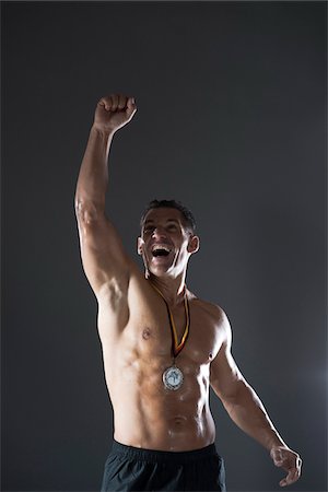 Muscular Man with Medal around Neck Cheering, Studio Shot Foto de stock - Sin royalties Premium, Código: 600-06841751