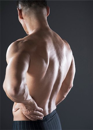 portrait 40s one person - Muscular Man with Hand on Lower Back, Studio Shot Stock Photo - Premium Royalty-Free, Code: 600-06841767